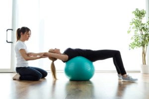 woman at physical therapy on a ball